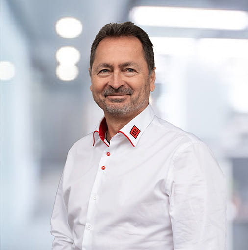 CSO Christian Trinko in weißem Hemd vor farbigem Hintergrund